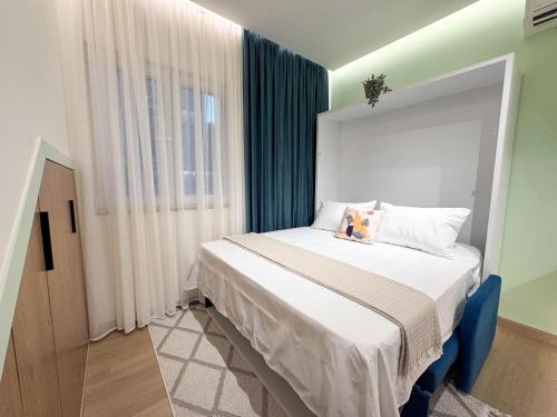ein kleines Schlafzimmer mit einem Bett mit Fenster in der Unterkunft Murphy Studio Near Everything in Tirana
