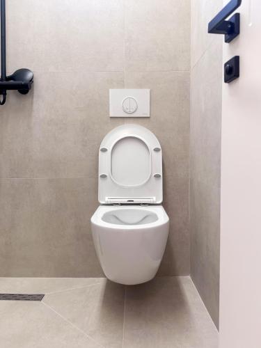 ein Badezimmer mit einer Toilette mit hochgeklapptem Sitz in der Unterkunft Murphy Studio Near Everything in Tirana