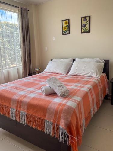 a bedroom with a bed with a blanket and a window at Hotel Villa Sofia in Nobsa