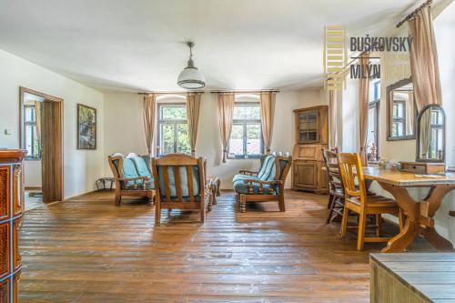 a living room with wooden chairs and a table at Buškovský mlýn 1580 in Dolní Bousov