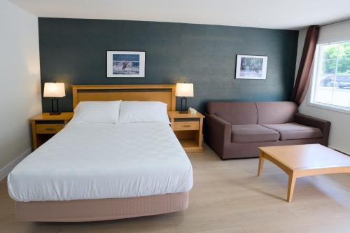 a bedroom with a bed and a couch and a chair at Park Motel in Hope