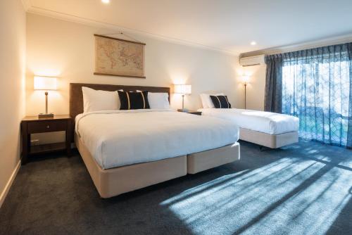 a hotel room with two beds and a window at Hanmer Springs Gateway Lodge in Hanmer Springs