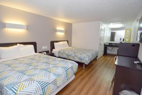a hotel room with two beds and a desk at Motel 6-Hamburg, NY in Hamburg