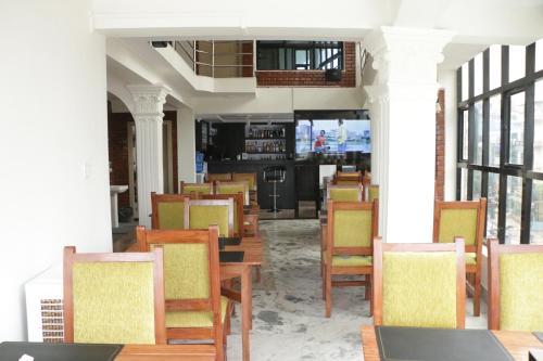 una sala da pranzo con sedie e tavoli in legno di Hotel Bharosa Inn a Kathmandu