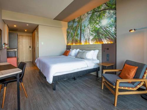 a hotel room with a bed and a table and chairs at Novotel Itu Terras de São José Golf & Resort in Itu