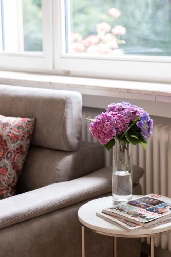 eine Vase mit lila Blumen auf einem Tisch in der Unterkunft EL Home - Stylish living and working near Frankfurt in Friedrichsdorf