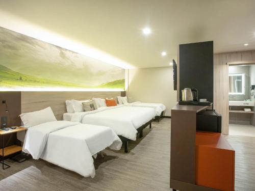 a hotel room with four beds and a television at Novotel Itu Terras de São José Golf & Resort in Itu