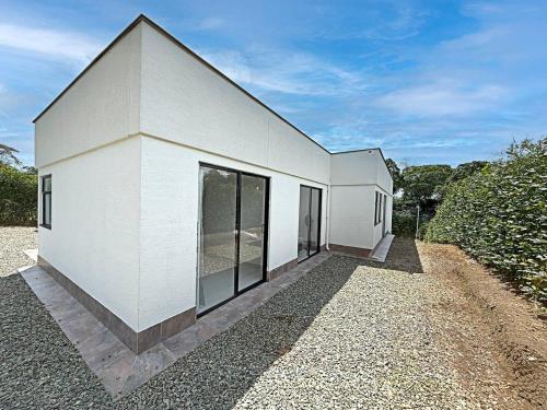a white building with large windows on the side of it at Nueva Finca, Piscina, Jacuzzi Y Fire Pit in Alcalá