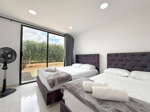 a bedroom with two beds and a fan and a window at Nueva Finca, Piscina, Jacuzzi Y Fire Pit in Alcalá