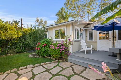 a small cottage with a chair and an umbrella at Seashore Retreat by Paradise Retreats in Montecito
