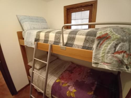 two bunk beds in a room with a window at Casa Morge Maison du soleil in Remondey