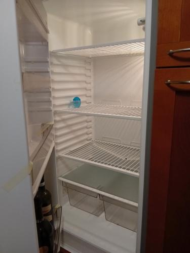 a white refrigerator with its door open with its shelves at Casa Morge Maison du soleil in Remondey