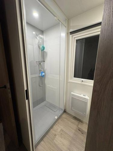 a glass shower in a bathroom with a window at Chalet De Bosrand Gasselte in Gasselte