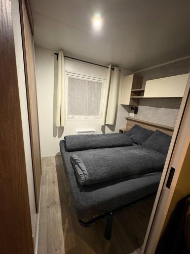 a small bedroom with a bed and a window at Chalet De Bosrand Gasselte in Gasselte