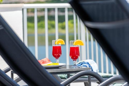 a table with two glasses of juice and a plate of fruit at Villa Senka in Rogotin