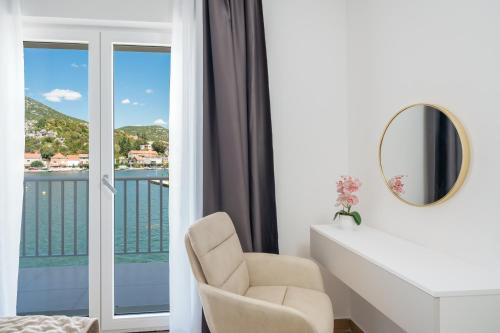 a white room with a chair and a mirror at Villa Senka in Rogotin