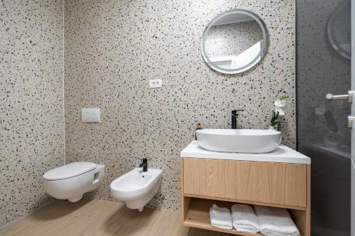a bathroom with a sink and a toilet and a mirror at Villa Senka in Rogotin