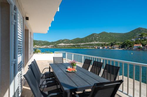 a table on a balcony with a view of the water at Villa Senka in Rogotin