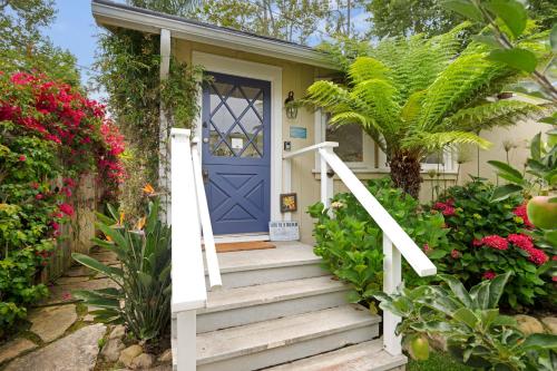 a house with a blue door and flowers at Seashore Retreat by Paradise Retreats in Montecito