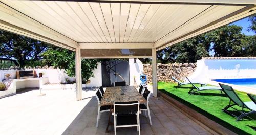 a patio with a table and chairs and a pool at Quinta Azul in Loulé