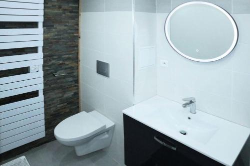 une salle de bain avec toilettes, lavabo et miroir dans l'établissement Résidence La Mazeliere - 16 MAZELIERE LES ORRES 1650 MAE-4934, aux Orres