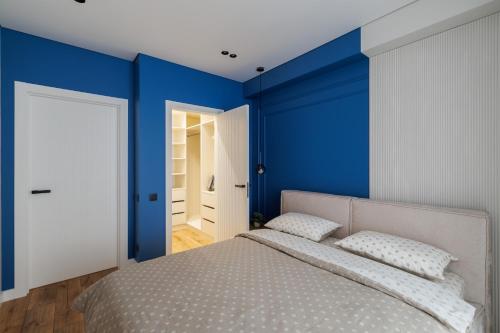 a bedroom with blue walls and a bed with pillows at Blue Studio in Crăsnăşeni