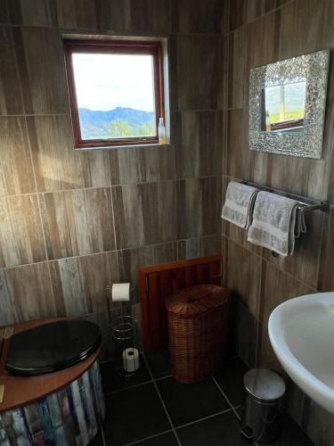 ein Badezimmer mit Waschbecken und Toilette und einem Fenster in der Unterkunft Renewal Retreat Klein Karoo Cottage in Uniondale
