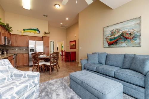 a living room with a blue couch and a kitchen at Cozy 2 Bedroom Monthly Rates Pets & Pool in Port Aransas