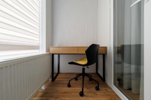 a desk with a chair next to a window at Blue Studio in Crăsnăşeni