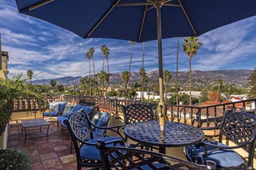 a patio with tables and chairs and an umbrella at Luxurious Mykonos in Santa Barbara with Outdoor Deck Short Bike Ride to Beach in Santa Barbara