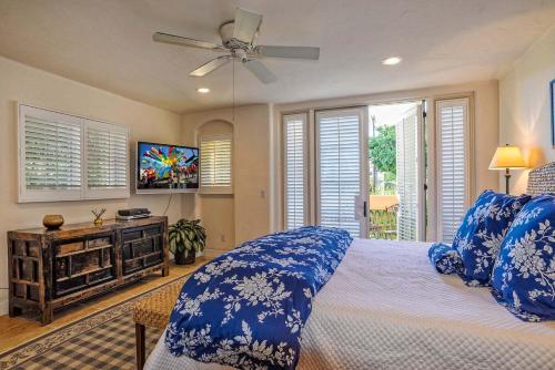 a bedroom with a bed with blue pillows and a ceiling fan at Luxurious Mykonos in Santa Barbara with Outdoor Deck Short Bike Ride to Beach in Santa Barbara