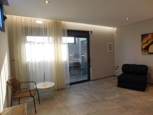 a living room with a black couch and a table at Kalon Gaia NOSTOS in Karistos