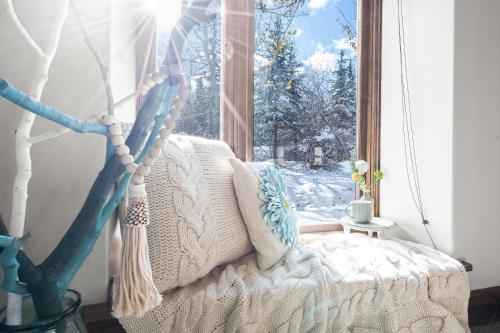 a bed in a room with a window with snow outside at Calming Canyons - Ski-in Ski-out Luxe Penthouse in Park City