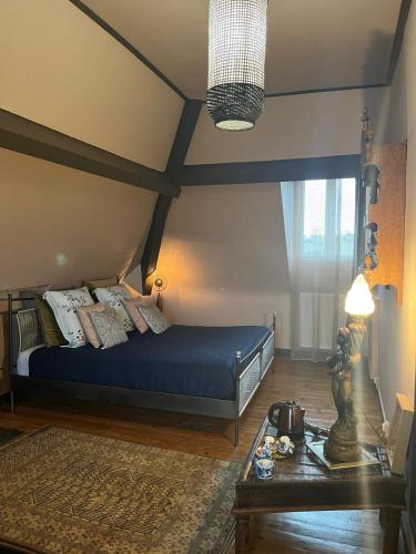a bedroom with a bed with blue sheets and pillows at Villa mon repos Annebecq in Landelles-et-Coupigny
