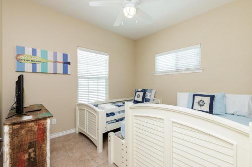 a bedroom with a crib and a tv in it at Fun 2 bedroom - Pets Pool Sleeps 6 in Port Aransas