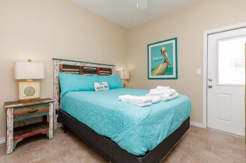 a bedroom with a blue bed with towels on it at Fun 2 bedroom - Pets Pool Sleeps 6 in Port Aransas