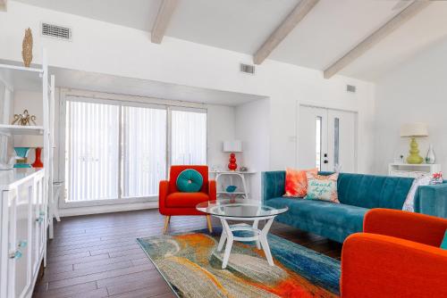 a living room with a blue couch and red chairs at Stylish 3 bedroom - Pool Pets Sleeps 10 in Port Aransas