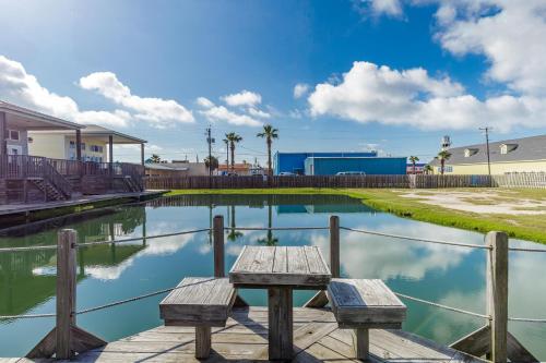 a picnic table sitting on a dock next to a pond at The Oasis - Pet Friendly Optional Golf Cart in Port Aransas