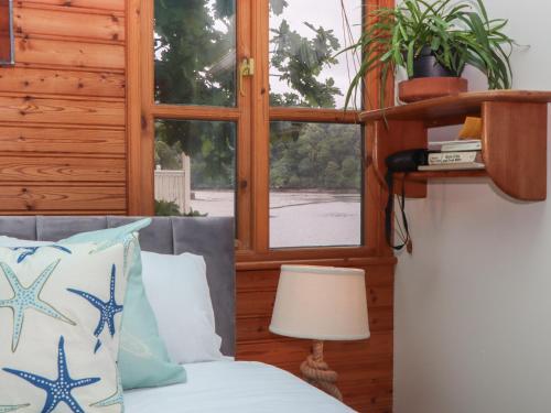 a bedroom with a bed and a window at The Sharpham Boat House in Totnes
