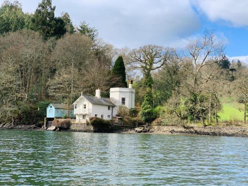 a house on the shore of a body of water at The Sharpham Boat House in Totnes