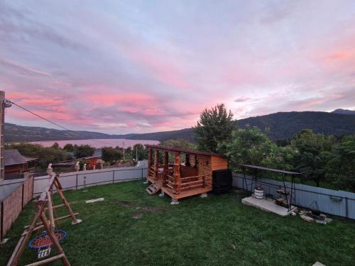 a backyard with a wooden house on the grass at Casa Victoria in Gura Hangului