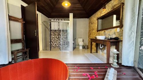 a room with a red bench and a bathroom at Estalagem Wiesbaden in Monte Verde