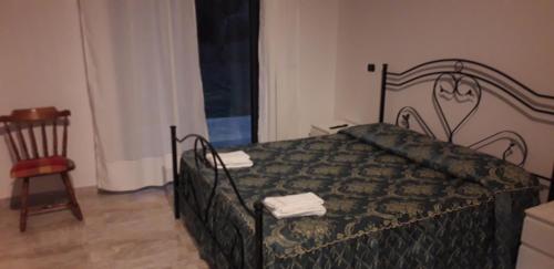 a bedroom with a bed and a chair and a window at Chora affittacamere in Morcone