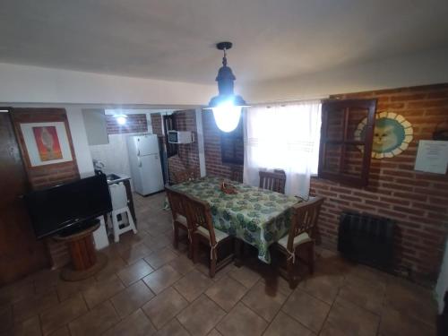a dining room with a table and chairs and a brick wall at Cabañas Guer Aike in Villa Carlos Paz