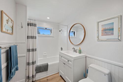 a white bathroom with a sink and a mirror at Ocean-View, Deck, Steps to Beach Dining and More in Solana Beach