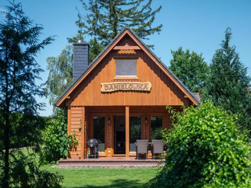 a log cabin with a sign on top of it at Domki w Parku in Pępowo