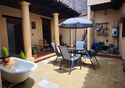 Un patio con una mesa y sillas y una sombrilla. en Casa Real de Mexicanos, en San Cristóbal de Las Casas