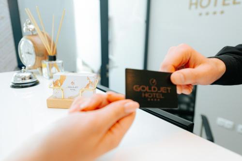a person is holding a card in front of a counter at Hotel GOLD JET Bihać in Bihać