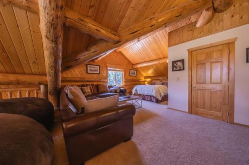 a log cabin bedroom with a bed and a couch at Maggies Cabin - Enjoy a Slice of Paradise in Rexford Montana in Rexford
