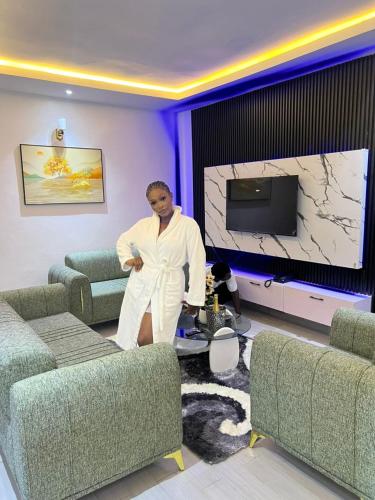a man is standing in a living room at Amelia Aparthotel in Buea